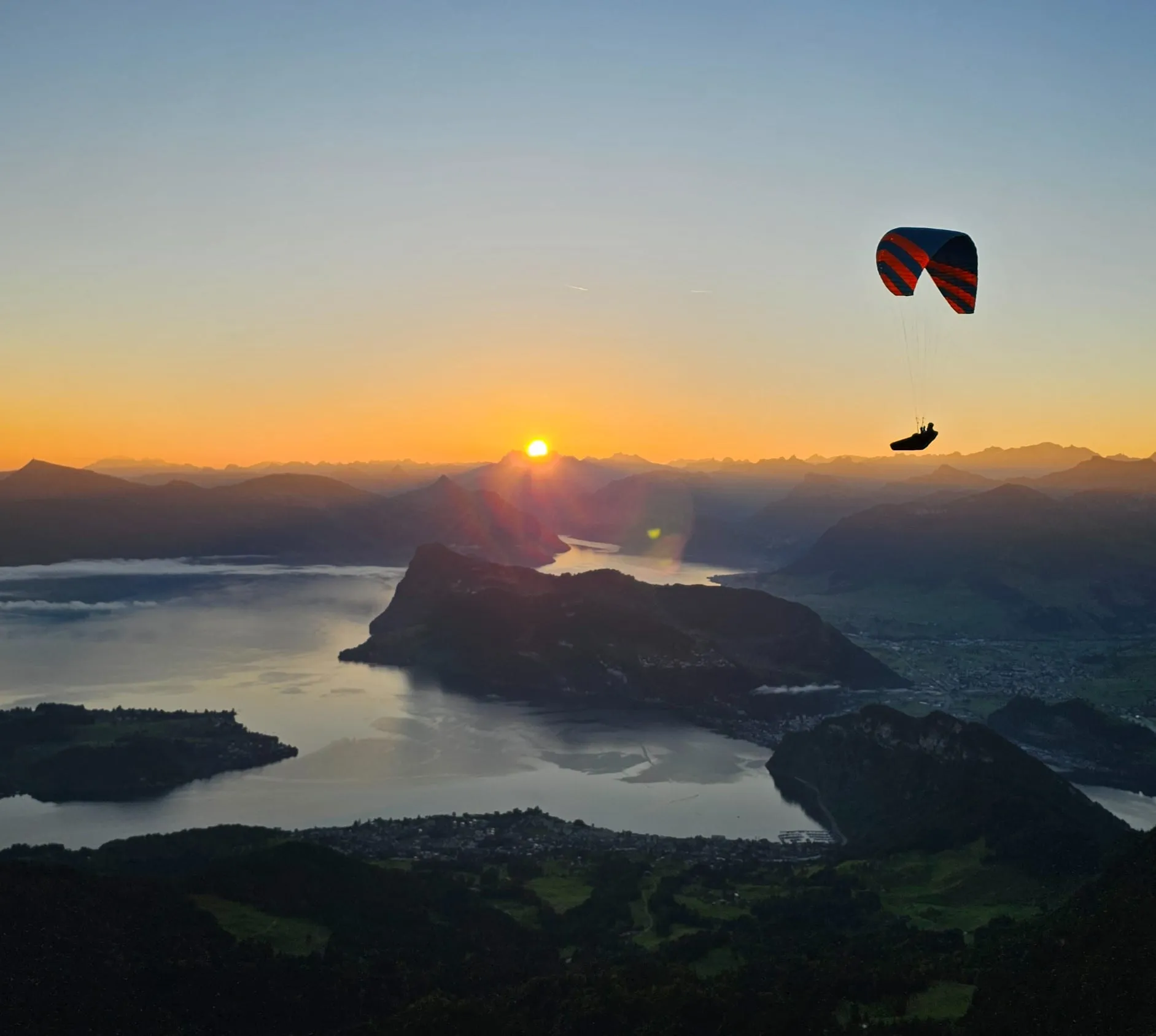 Gleitschirm im Sonnenaufgang über dem Vierwaldstättersee